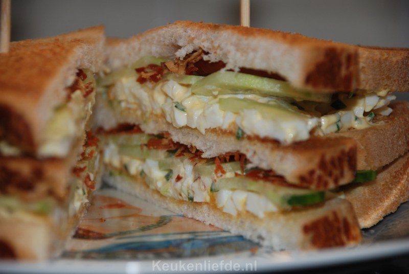 Club sandwich met eiersalade, bacon en komkommer
