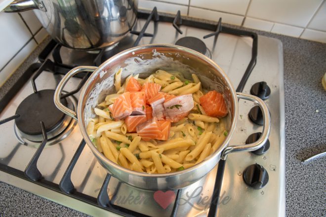 Roer pasta en zalm door de saus