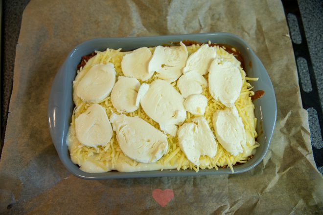 Bouw lagen saus en lasagnebladen op in de ovenschaal.