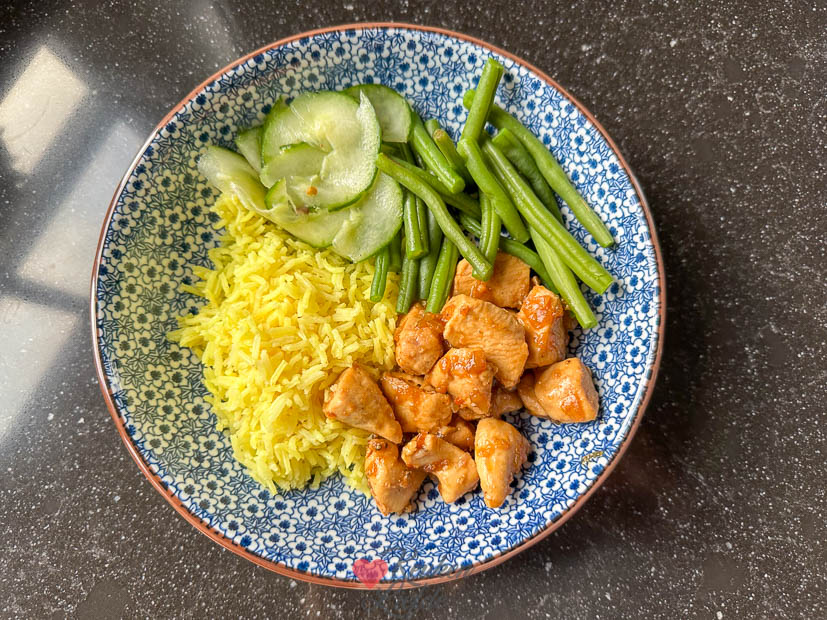 Kip ketjap met gele rijst, boontjes en komkommersalade